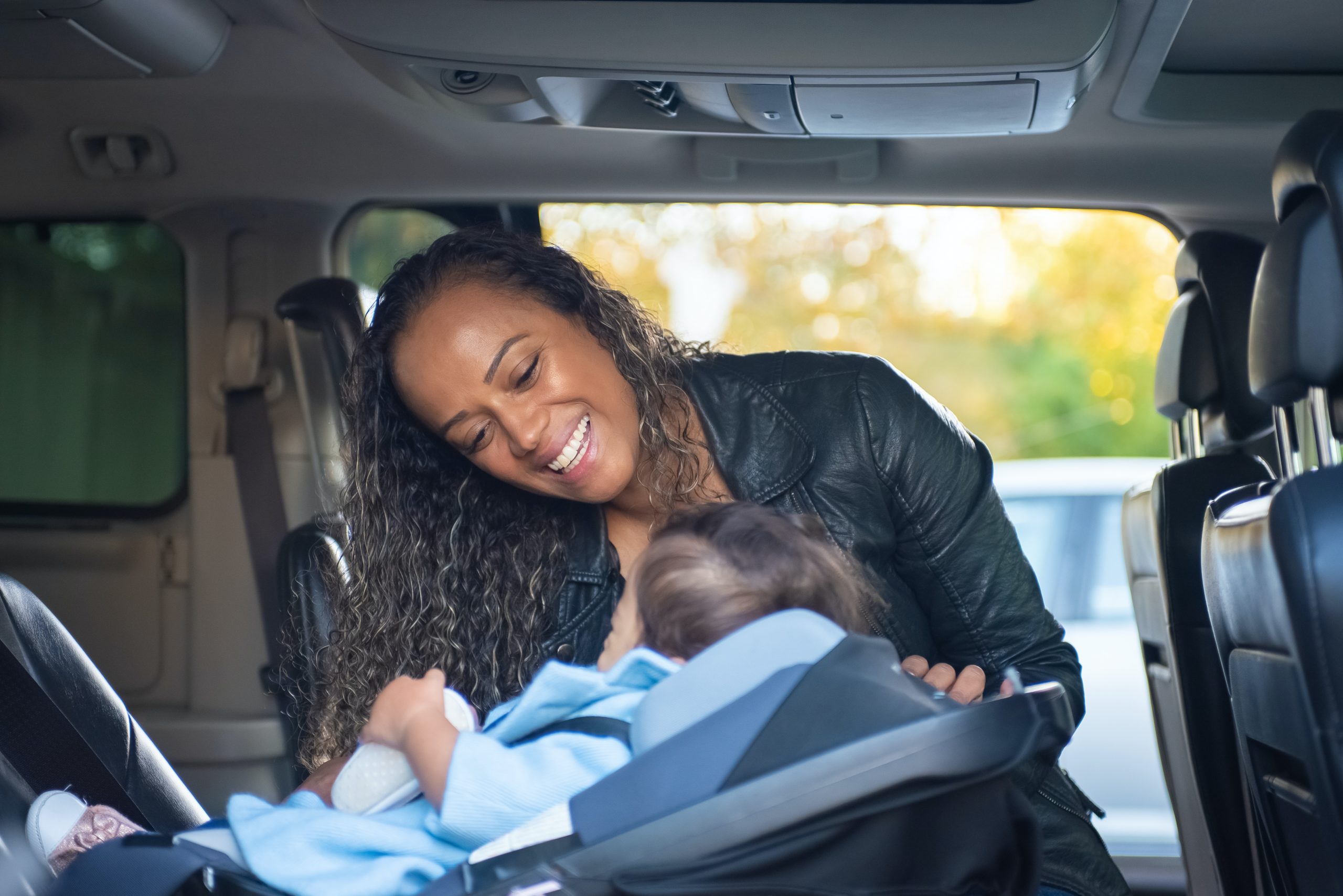 woman in back of car with baby